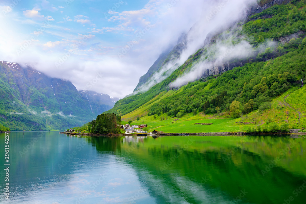 Beautiful idyllic landscape of the fjord Naeroyfjord in Gudvangen, Norway. A small traditional Scandinavian village on the picturesque coast of the fjord between the mountains. Travel background