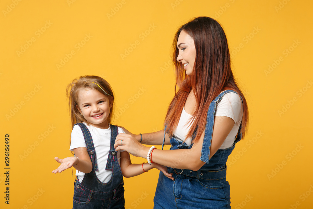 Woman in light clothes have fun with cute child baby girl 4-5 years old. Mommy little kid daughter isolated on yellow background studio portrait. Mother's Day love family parenthood childhood concept. Woman in light clothes have fun with cute child baby girl 4-5 years old. Mommy little kid daughter isolated on yellow background studio portrait. Mother's Day love family parenthood childhood concept.