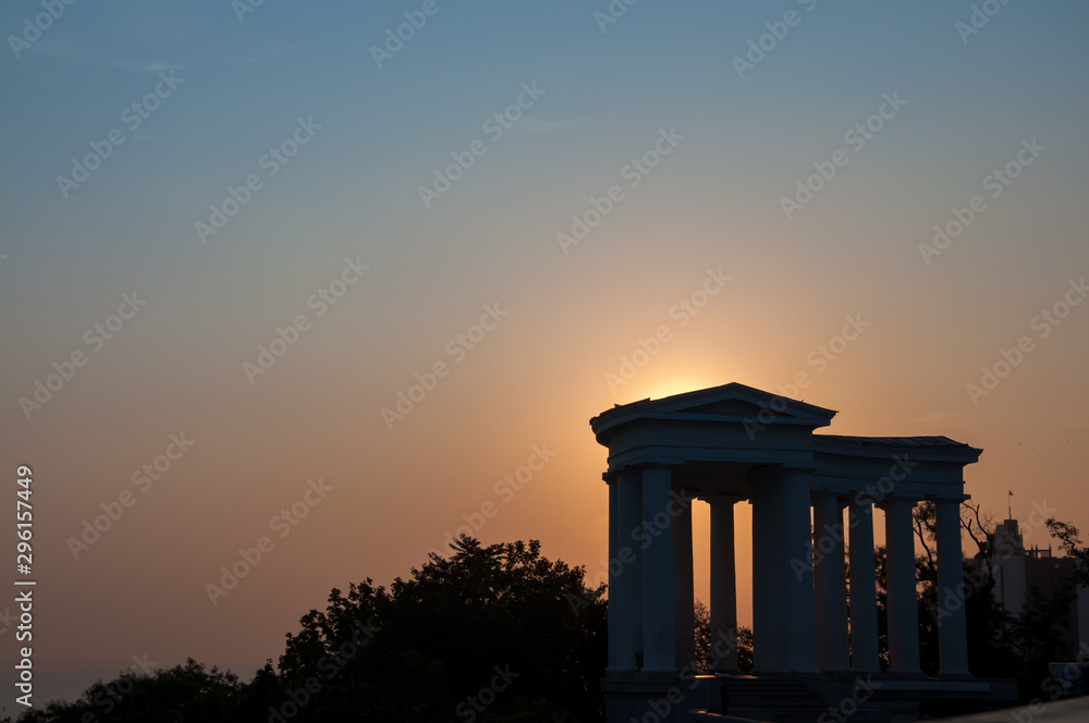 Fototapeta premium Dark silouette of the Odessa colonnade, with sun rising behind.