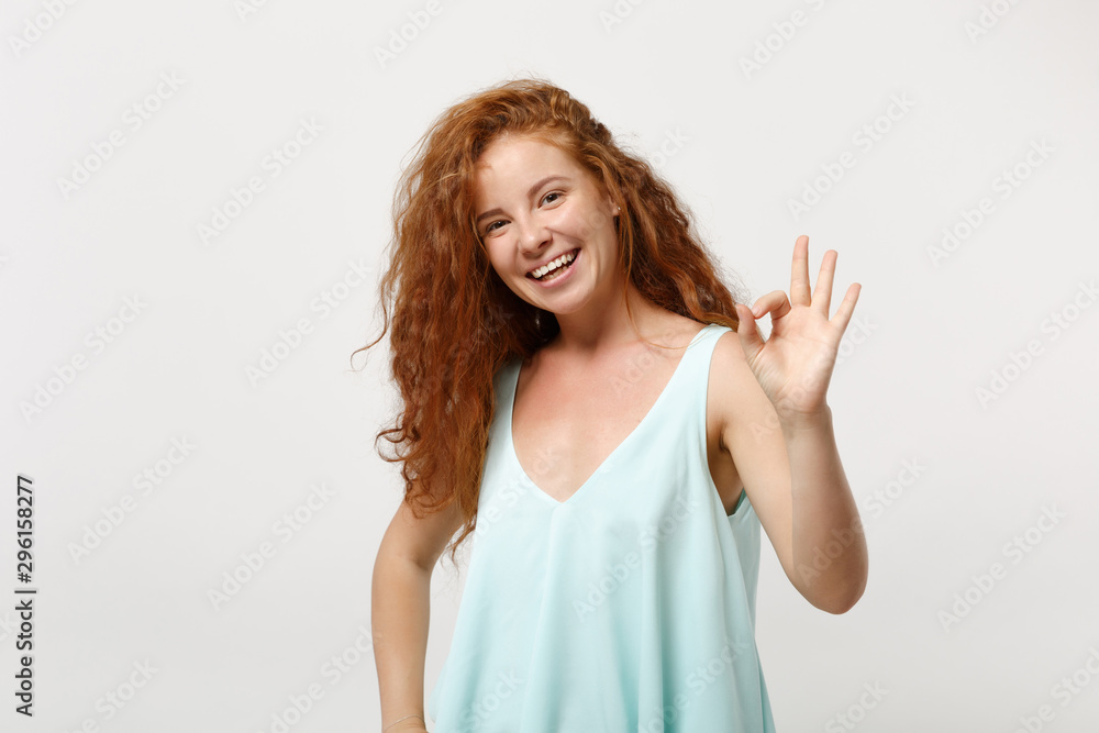 Young laughing redhead woman girl in casual light clothes posing isolated on white wall background, studio portrait. People sincere emotions lifestyle concept. Mock up copy space. Showing OK gesture. Young laughing redhead woman girl in casual light clothes posing isolated on white wall background, studio portrait. People sincere emotions lifestyle concept. Mock up copy space. Showing OK gesture.