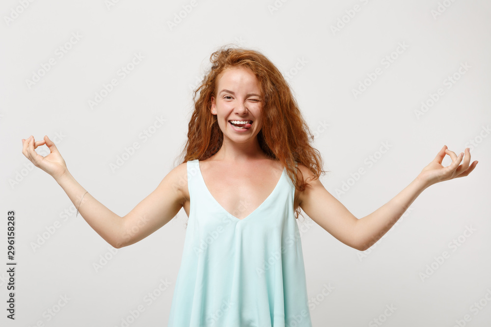 Young cheerful redhead woman in casual light clothes posing isolated on white background. People lifestyle concept. Mock up copy space. Hold hands in yoga gesture, relaxing meditating, showing thumb. Young cheerful redhead woman in casual light clothes posing isolated on white background. People lifestyle concept. Mock up copy space. Hold hands in yoga gesture, relaxing meditating, showing thumb.