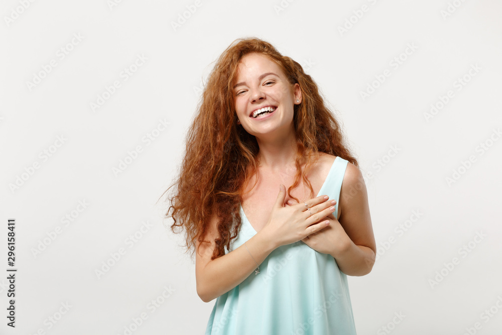 Young funny smiling redhead woman in casual light clothes posing isolated on white background in studio. People sincere emotions lifestyle concept. Mock up copy space. Keeping hands on chest, heart. Young funny smiling redhead woman in casual light clothes posing isolated on white background in studio. People sincere emotions lifestyle concept. Mock up copy space. Keeping hands on chest, heart.