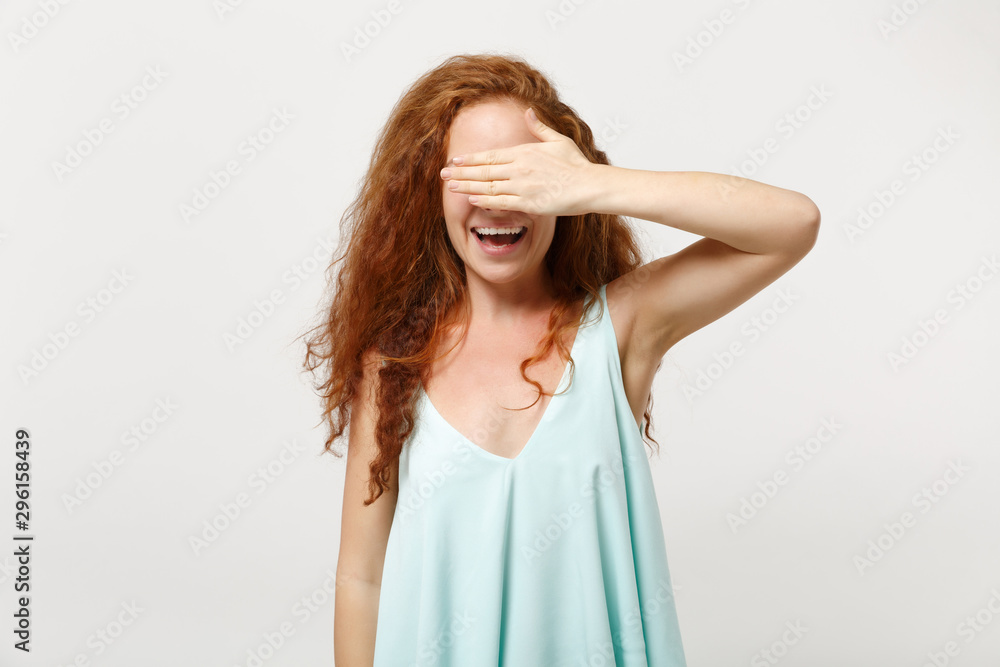 Young laughing redhead woman in casual light clothes posing isolated on white wall background in studio. People sincere emotions lifestyle concept. Mock up copy space. Covering eyes with hand, hiding. Young laughing redhead woman in casual light clothes posing isolated on white wall background in studio. People sincere emotions lifestyle concept. Mock up copy space. Covering eyes with hand, hiding.