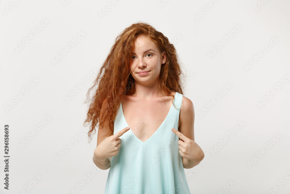 Young confused redhead woman girl in casual light clothes posing isolated on white background in studio. People sincere emotions lifestyle concept. Mock up copy space. Point index fingers on herself.