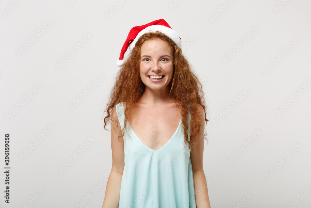 Beautiful young redhead Santa girl in light clothes, Christmas hat isolated on white background, studio portrait. Happy New Year 2020 celebration holiday concept. Mock up copy space. Looking camera. Beautiful young redhead Santa girl in light clothes, Christmas hat isolated on white background, studio portrait. Happy New Year 2020 celebration holiday concept. Mock up copy space. Looking camera.