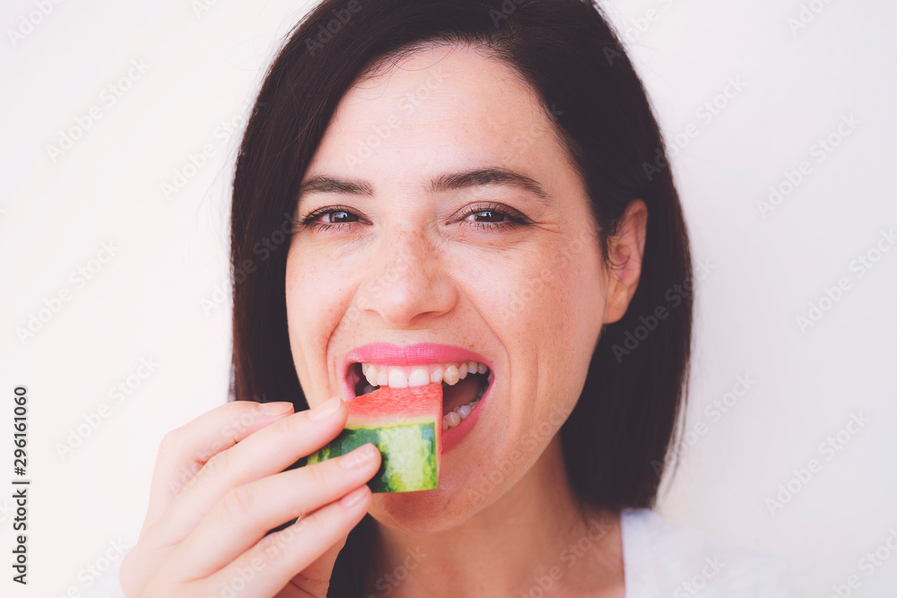 happy young woman is eating slice of watermelon over white background happy young woman is eating slice of watermelon over white background