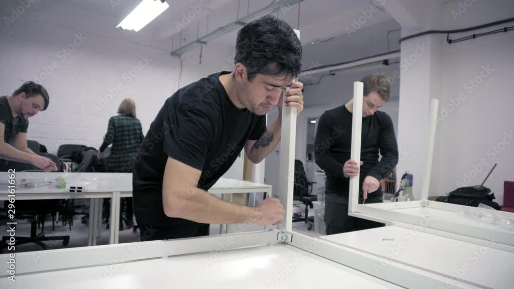 Men assembling new office desks Men assembling new office desks
