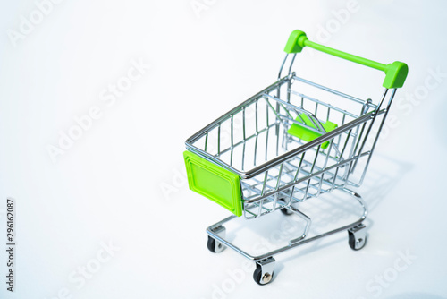 Empty green miniature shopping cart isolated on white background.