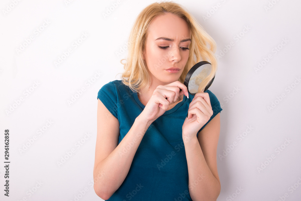 beautiful blond girl hair concept holding magnifier damaged hair ends and healthy hair care concept