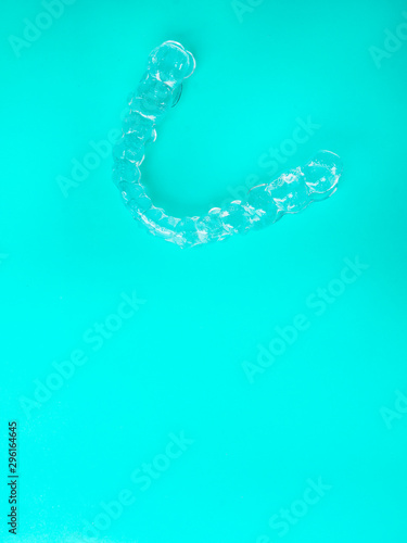 Invisible dental aligners modern tooth brackets on blue background, transparent braces to straighten teeth in cosmetic dentistry and orthodontics