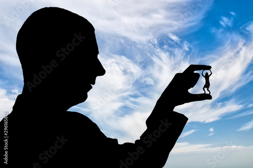Fotografía Bullying. Silhouette of a man holds a woman between his fingers