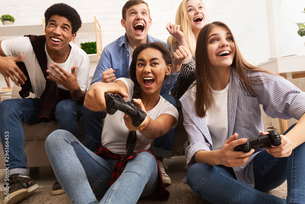 Playful friends playing video games online and having fun Stock