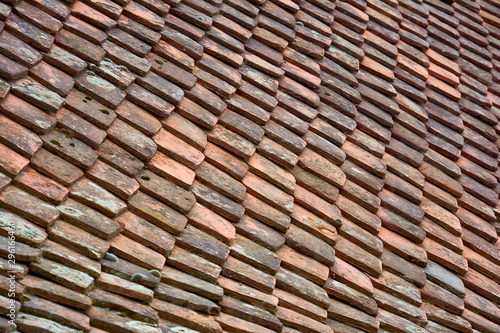 Antique ceramic multi-colored roof tiles. Background image of terracotta roof tiles closeup.