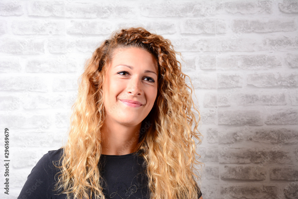 Beautiful young business woman isolated over brick wall background. Attractive 27 year old girl with beautiful smile. Portrait of girl smile while standing against brick wall background. Beautiful young business woman isolated over brick wall background. Attractive 27 year old girl with beautiful smile. Portrait of girl smile while standing against brick wall background.