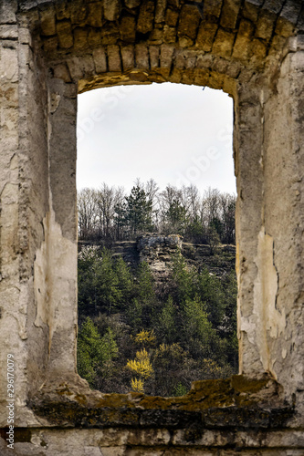 View of the mountain landscape through the window of an old dilapidated synagogue. Old stonework. Mountains  forest  ruins. Rashkov  Moldova.