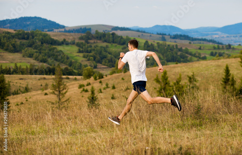 Wallpaper Mural Running fitness man sprinting outdoors with beautiful mountains landscape on background. Caucasian sport male runner training for marathon. Torontodigital.ca