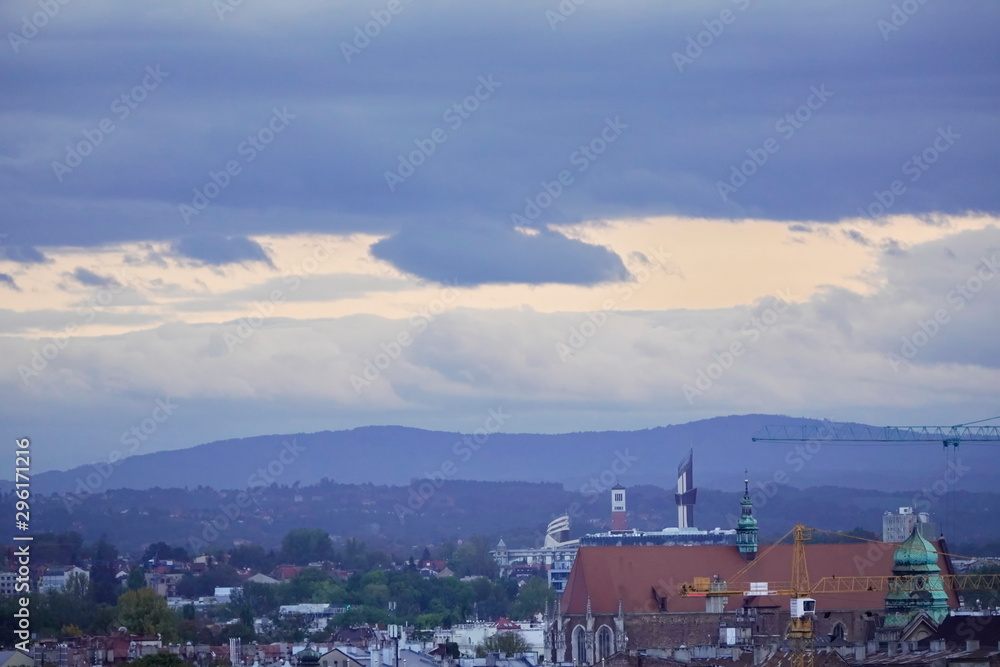 roofs of houses and a Church at sunset, the dark sky with clouds before a thunderstorm. old town top view. the observation deck on the roof
