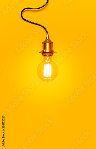 Vintage fashionable edison lamp on bright yellow background. Top view flat lay copy space. Creative idea concept, designer lamp, modern interior item. Lighting, electricity, background with lamp