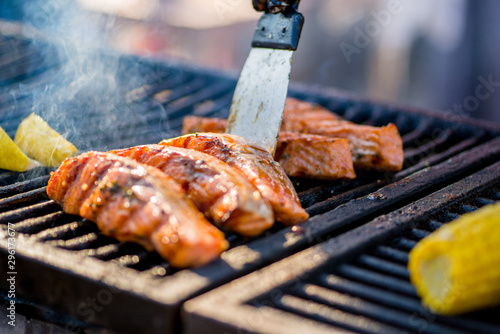 Canvas Print Cooking BBQ Fish.Gloved hands turn pieces of fish on the grill.