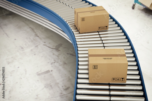 Obraz na płótnie Cardboard boxes on conveyor rollers ready to be shipped by courier for distribut