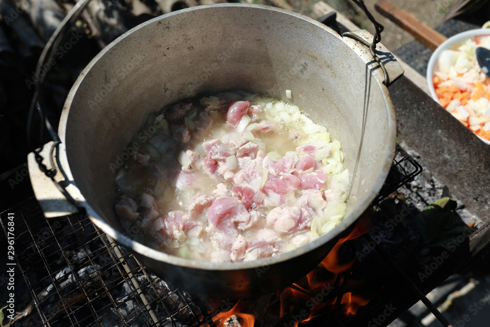 Frying meat with onions in cauldron Frying meat with onions in cauldron