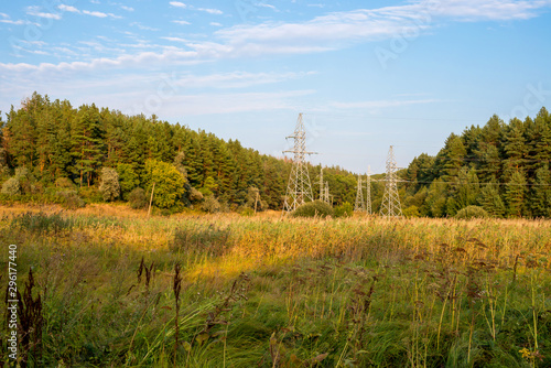Power line with metal supports on forest background