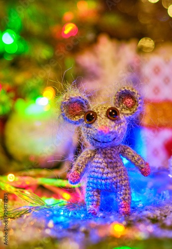 Knitted mouse is surrounded by Christmas decorations. Year of rat. symbol of 2020.