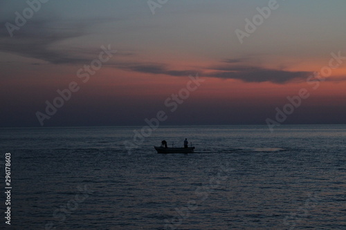 silhouette of fisherman at sunset © eric