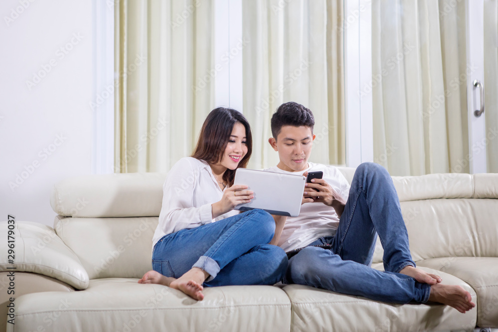 Couple enjoying leisure time with tablet and phone