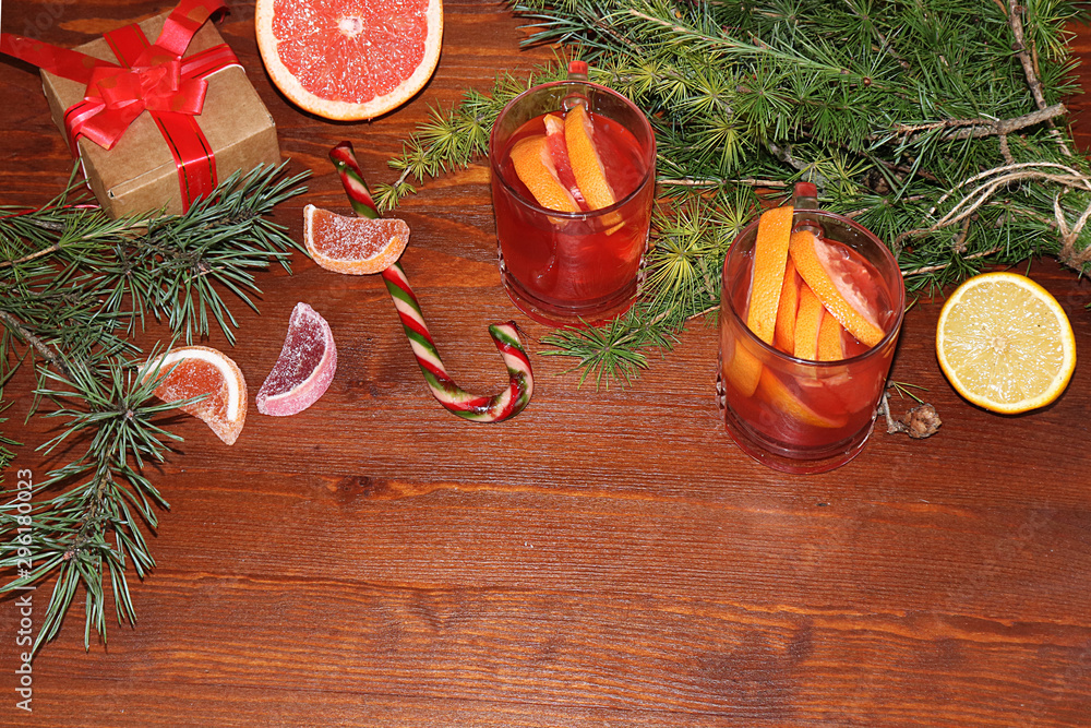Christmas hot mulled wine with lemon and cinnamon on a festive wooden table. Christmas blanks with gifts, sweets and toys, spruce branches, flat lay Christmas hot mulled wine with lemon and cinnamon on a festive wooden table. Christmas blanks with gifts, sweets and toys, spruce branches, flat lay