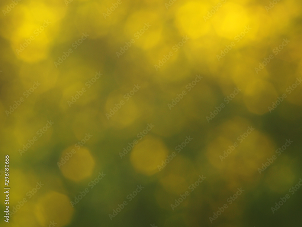 Obraz premium Green and yellow colored abstract light background.Natural outdoors bokeh backdrop in green and yellow tones with sun rays. Abstract blur spring meadow pattern. 