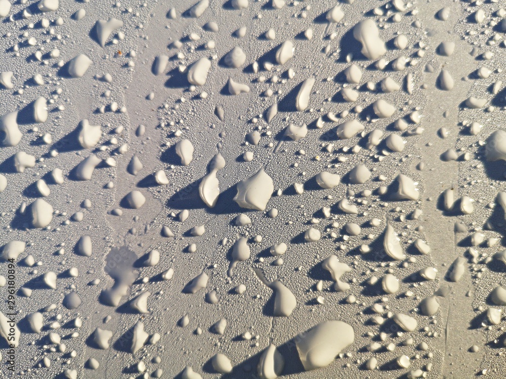 Water drops on a white car - abstract background Water drops on a white car - abstract background
