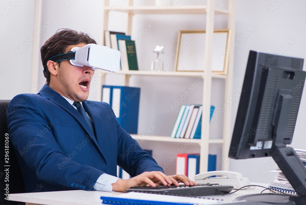 Employee using virtual reality glasses in office Employee using virtual reality glasses in office
