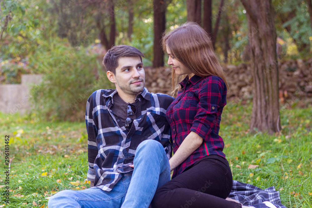 man and woman in plaid shirts in the autumn park. Happy couple in love