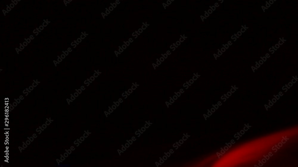 Curly creeping puffs of smoke on a dark background, illuminated by light with different colors. Curly creeping puffs of smoke on a dark background, illuminated by light with different colors.