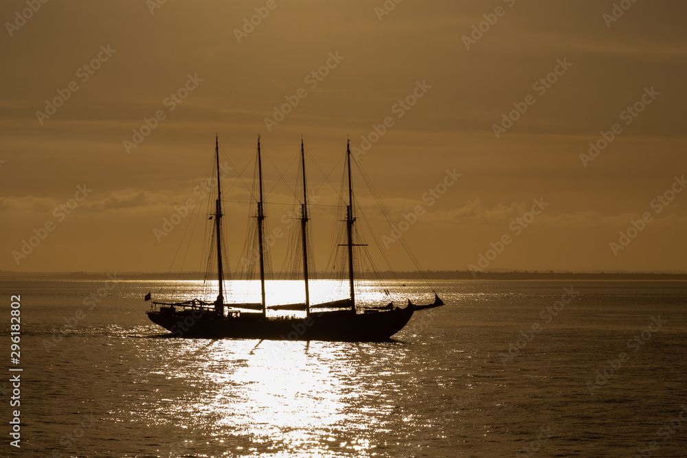 Fototapeta premium Four masts sailing ship at sea photo taken against sun