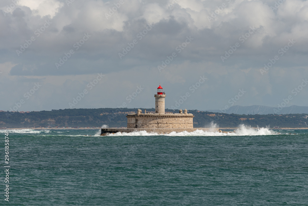 Lighthouse on small island at sea - The Fort of Sao Lourenco do Bugio
