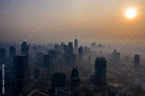 Skyscrapers covered by air pollution at sunset