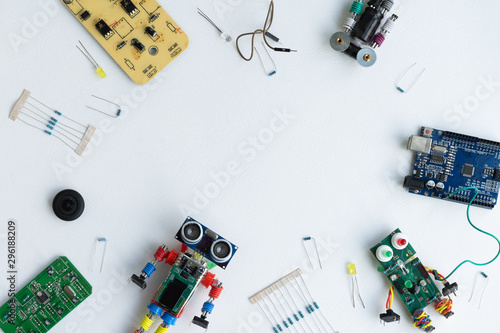STEM school concept. A metal robot and an electronic board that can be programmed. Robotics and electronics. DIY robotics. STEM education for kids. Flat lay. Free space for text. White background.