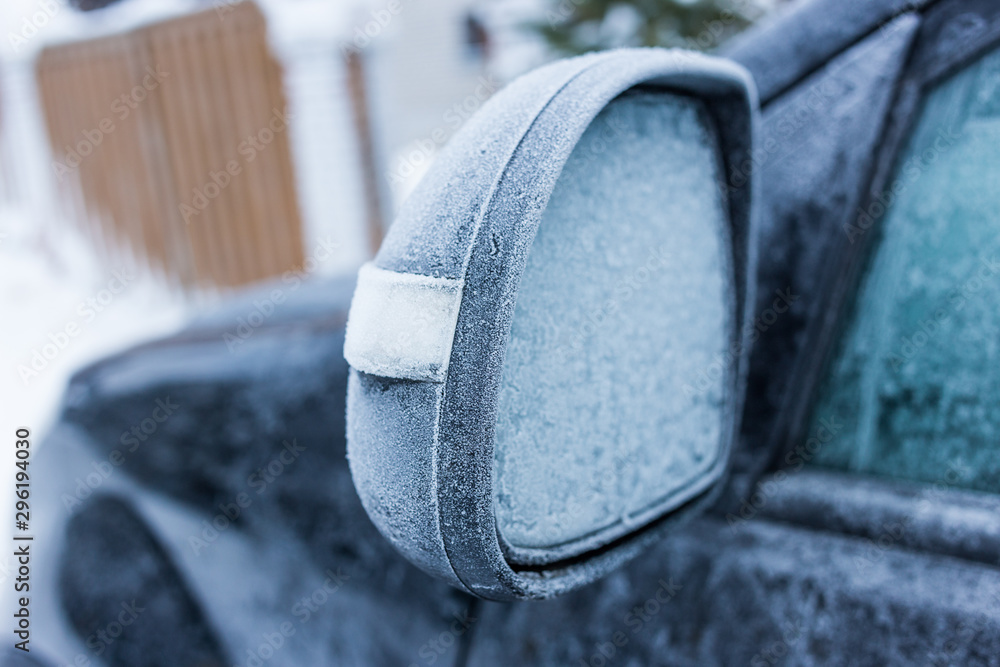 Car's side view mirror of a modern car covered with snow Car's side view mirror of a modern car covered with snow