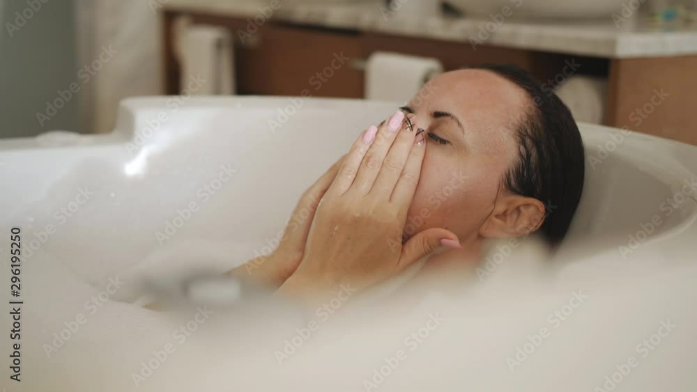 Pretty woman relaxing in a bathtub full with foam Pretty woman relaxing in a bathtub full with foam