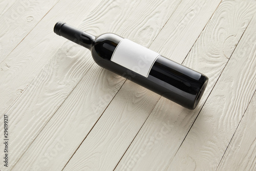 bottles with wine and blank label on white wooden surface