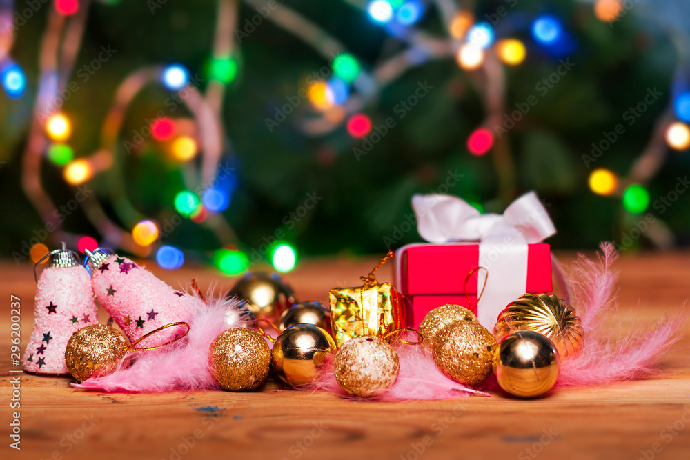 Christmas toys on wooden table against the decorated Christmas Tree. Xmas festive decorations on wood. Holiday background image