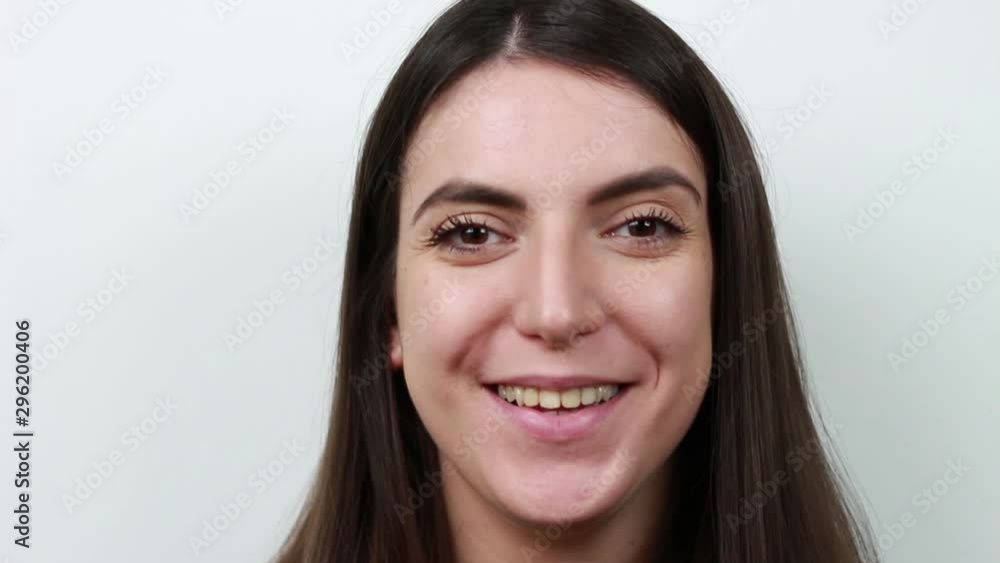 Brown-haired woman squinting at the camera. Laughter. Have fun.Girl with dark brown hair. Brown-haired woman squinting at the camera. Laughter. Have fun.Girl with dark brown hair.