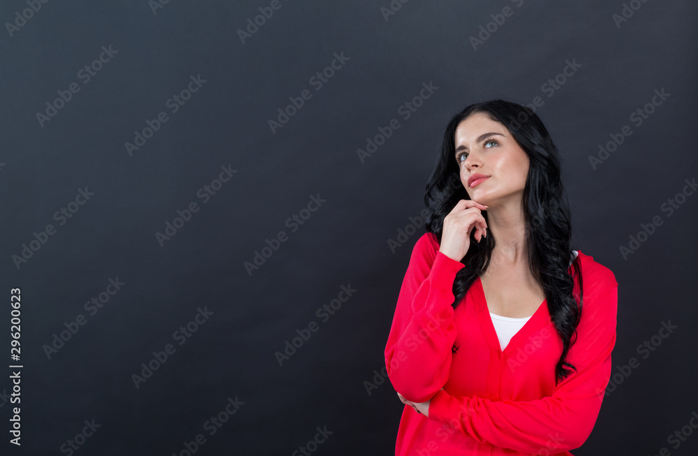 Young woman in a thoughtful pose on a black background Young woman in a thoughtful pose on a black background