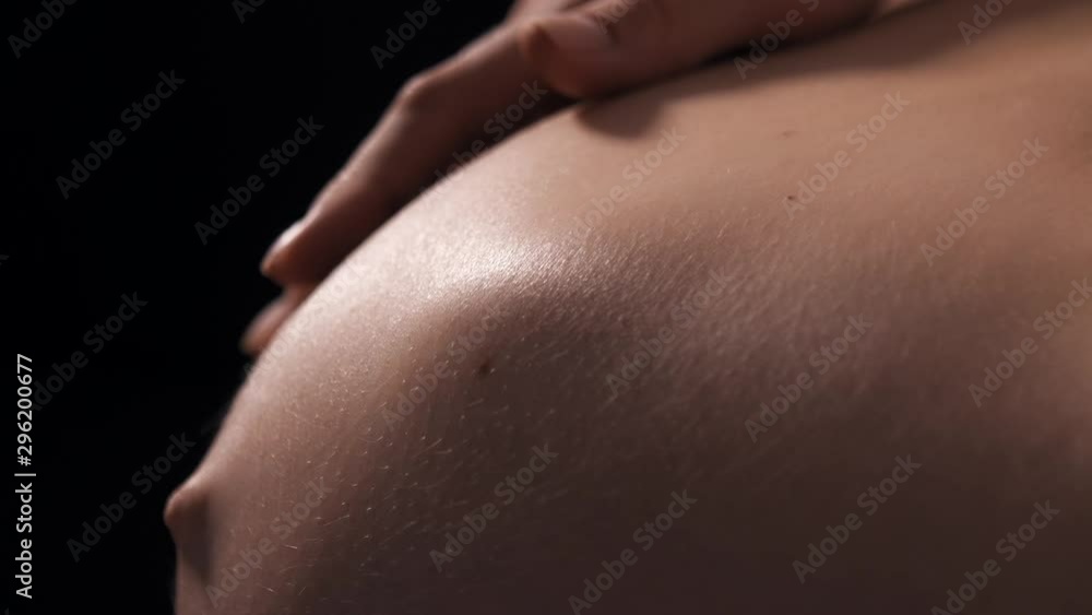 Close-up of pregnant woman with baby moving and kicking inside belly, future mother carefully touch tummy and playing with her baby. Last trimester of pregnancy Close-up of pregnant woman with baby moving and kicking inside belly, future mother carefully touch tummy and playing with her baby. Last trimester of pregnancy