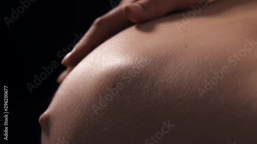Close-up of pregnant woman with baby moving and kicking inside belly, future mother carefully touch tummy and playing with her baby. Last trimester of pregnancy photo