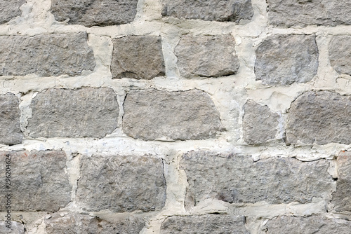 Seamless texture of large masonry from hand-carved blocks of a fortified wall with lime mortar.