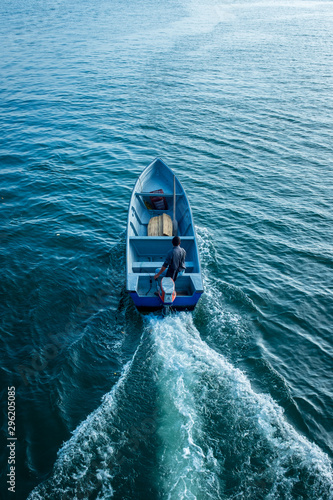 Fototapeta Tumaco, Nariño / Colombia, June 27, 2019: Man on Blue Empty Speed Boat in The Ba