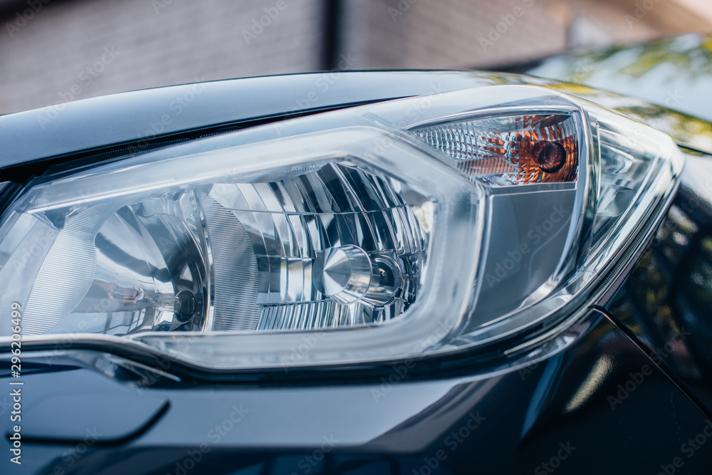Close up view of clean, polished headlamp of modern car